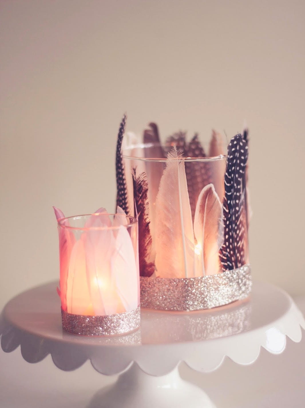 Создать невероятно романтическую обстановку можно с помощью декоративных подсвечников, выполненных из стеклянных стаканов и красивых перьев