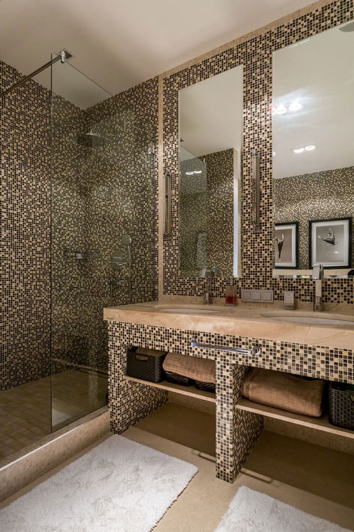 Декоративная мозаика в интерьере ванной комнаты смотрится очень красиво, особенно когда её украшают прозрачные стекла и зеркала